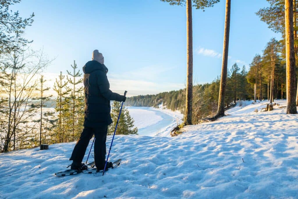Kvinna som går med snöskor utanför campingområdet på Arcus - Luleå