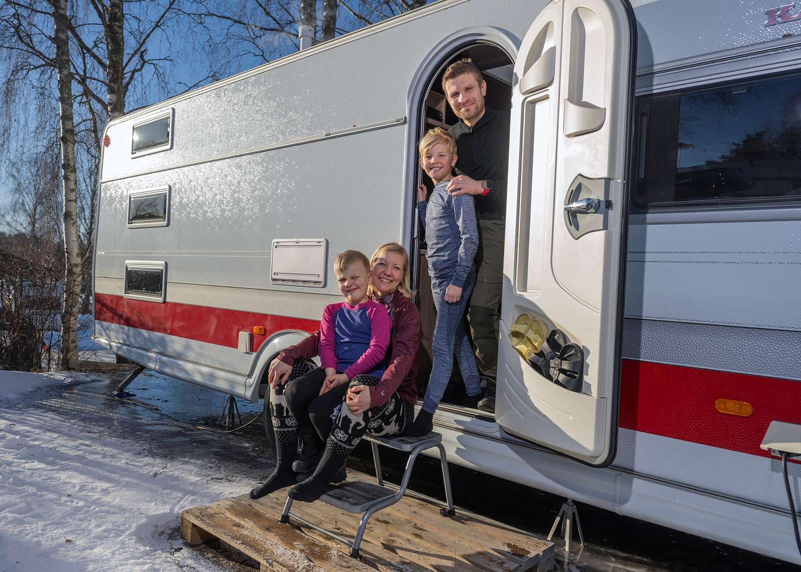 Vintercamping familj intill husvagnen