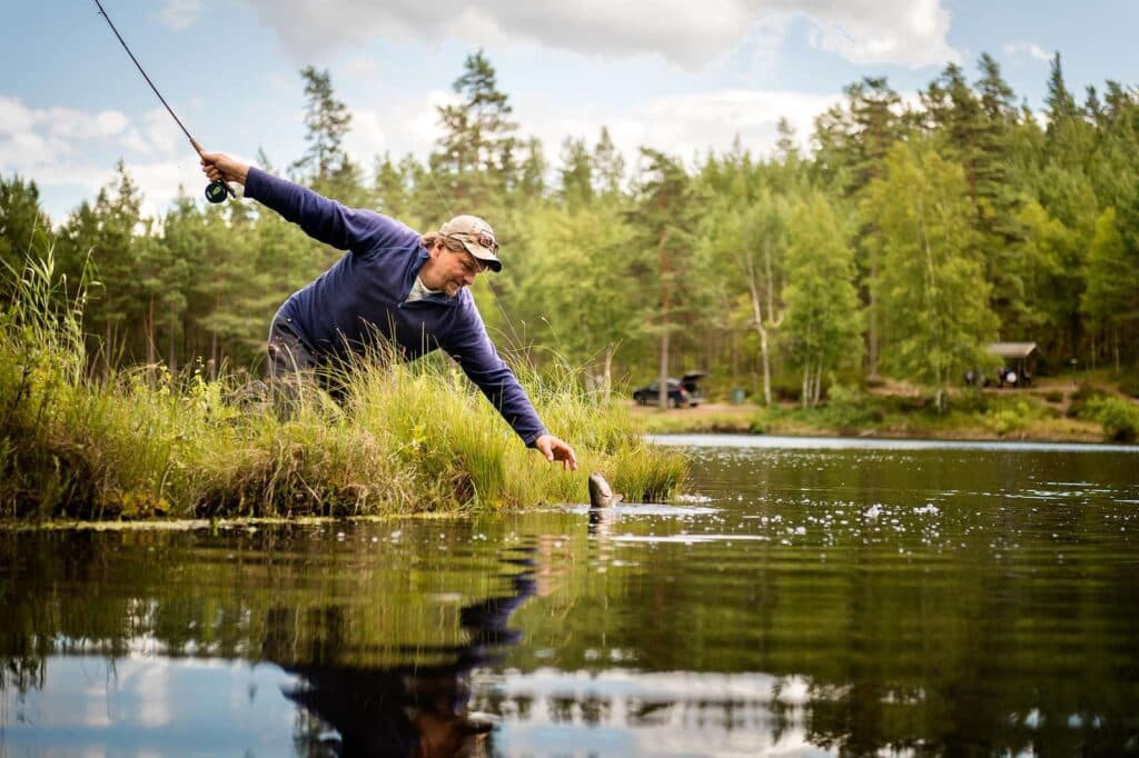 Man som fiskar vid en sjö.