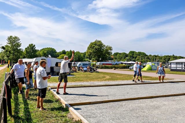 Västerås Mälaren människor som står inne på campingområdet och spelar boule