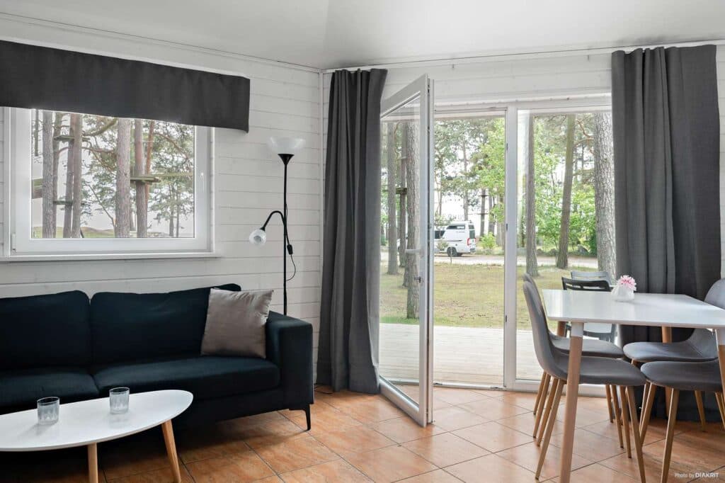 Överblick över soffa och matbord inuti Strandstugan på Åhus