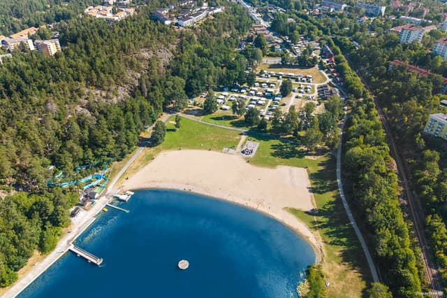 Överblickbild över stranden, vattnet, naturen och delar av campingområdet på Nickstabadet Nynäshamn