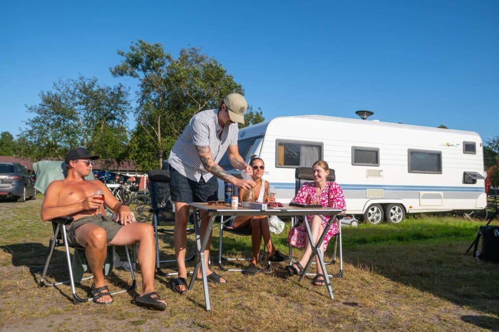 Familj som kopplar av vid husvagnen på Nydala Umeå camping