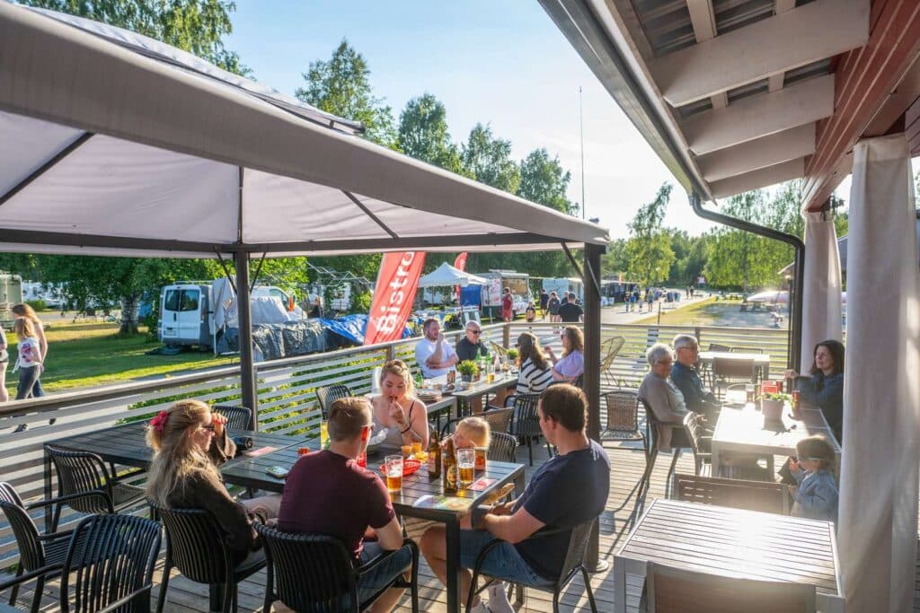 Gäster som njuter av campinglivet och äter gott på bistron på Nydala Umeå camping