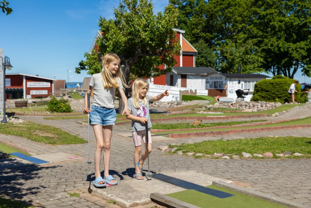 Barn som spelar minigolf på Campingen Gränna - Vättern i Jönköpings kommun