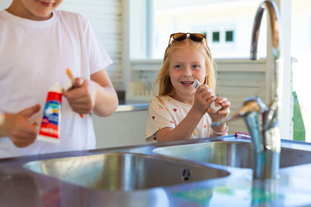 barn som står och borstar tänderna i servicehus på Skara Sommarland camping