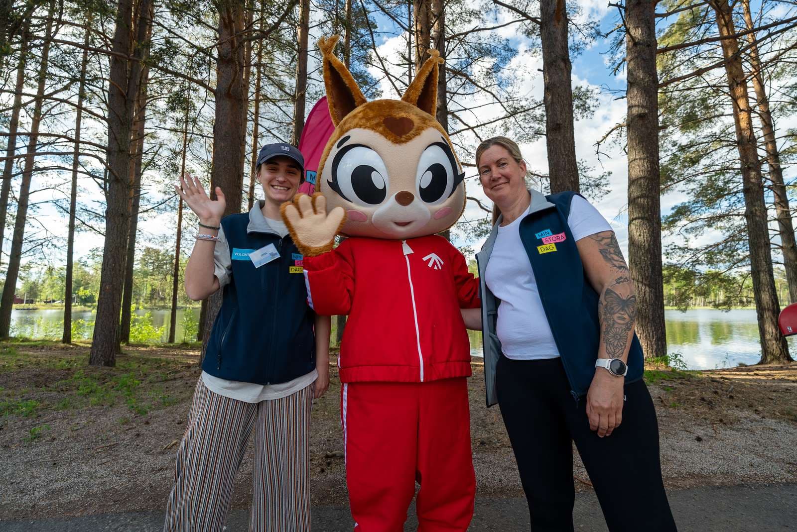Min Stora Dag Moraparken två från personalen som står bredvid maskoten Yessi och vinkar