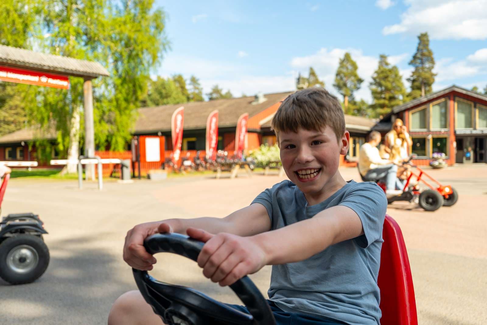 Min Stora Dag Moraparken barn som åker tranpbil och ler stort mot kameran